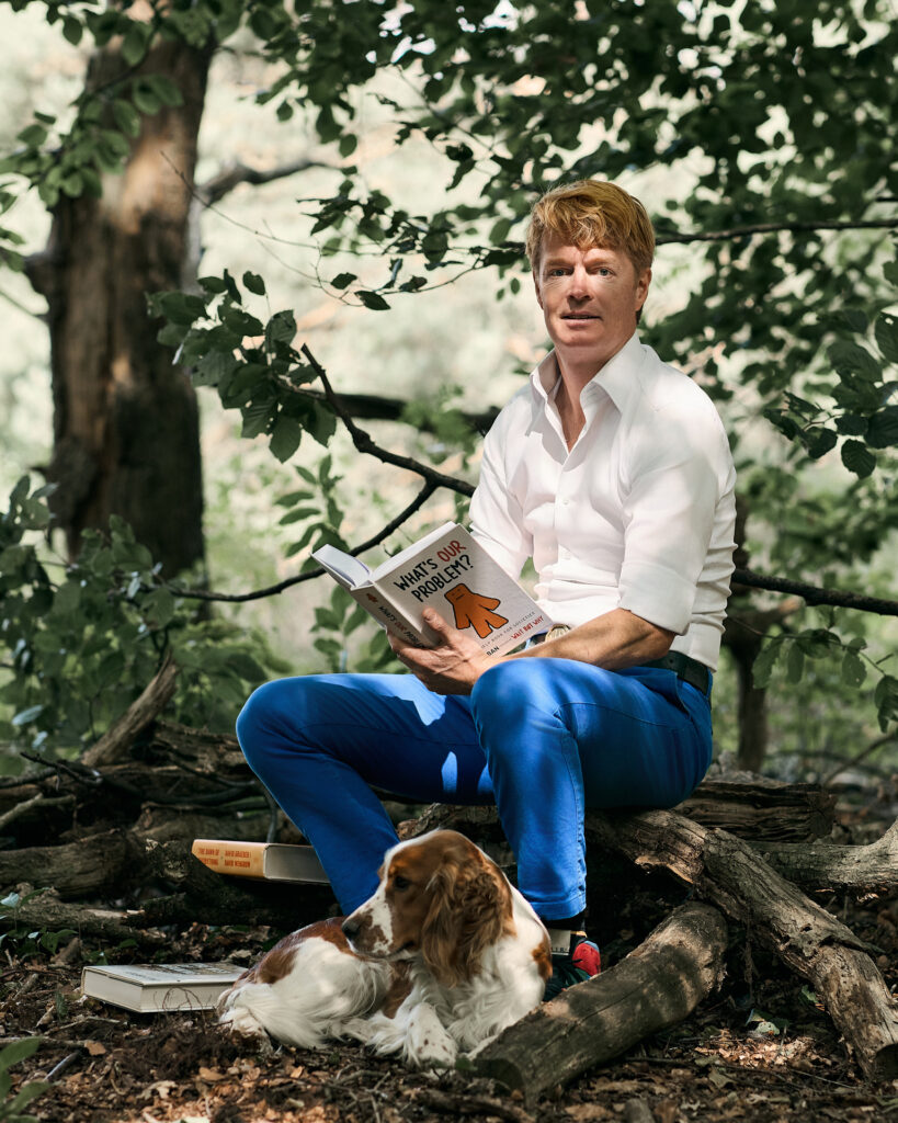 Sicco zittend op een tak met boek en Welsh Springer Spaniel liggend bij hem